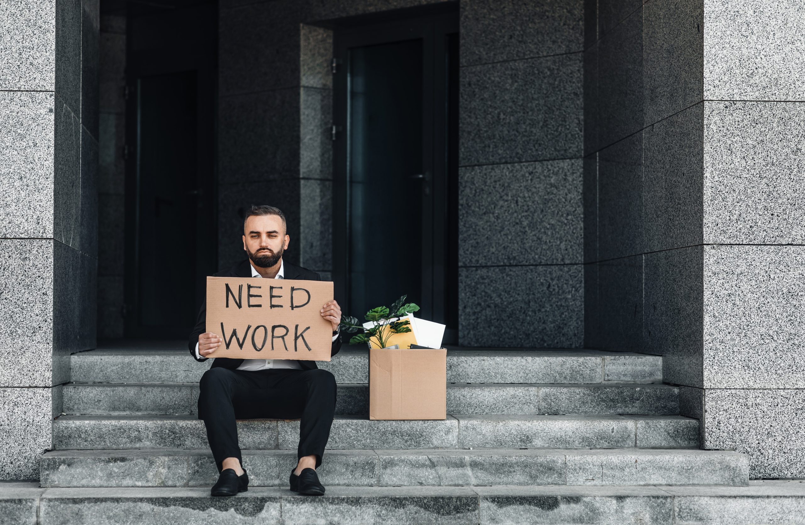 unemployed man sitting on steps