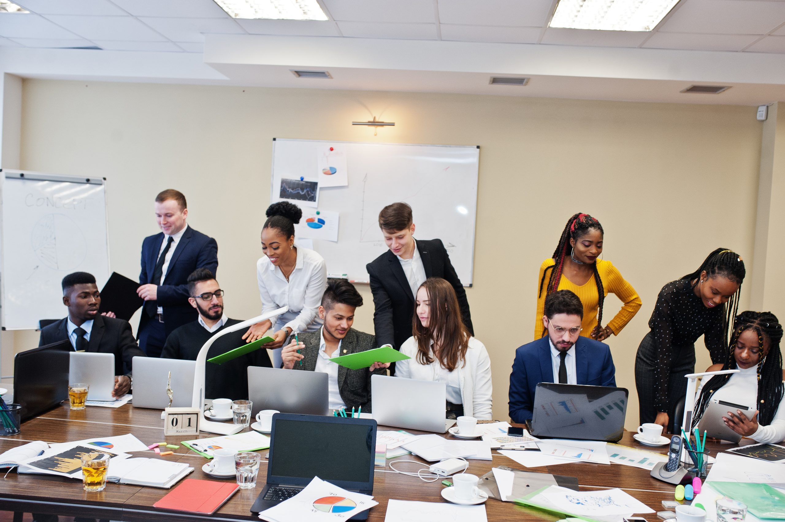Multiracial young creative people in modern office. Group of young business people are working together with laptop, tablet. Successful freelancers team in coworking.